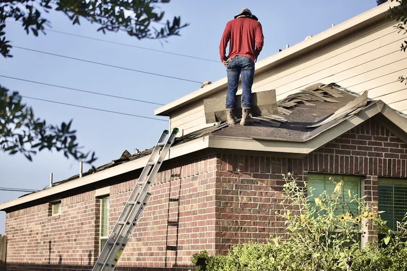 Professional roofer working on a residential roof in Friesville